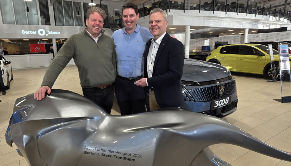Fv: Direktør for varebil Roy Erik Johnsen, daglig leder Lars Hoff hos Bertel O. Steen Trondheimog direktør for Peugeot Norge, Rune Hensel foran løven, som blir stående hos BOS Trondheim gjennom 2025 som et synlig bevis på prestasjonene i 2024.